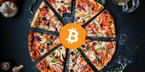 bitcoin logo in front of cut pizza