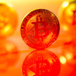 A bitcoin shown against a reddish orange glare.