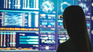 Investor looking at wall of trading screens.